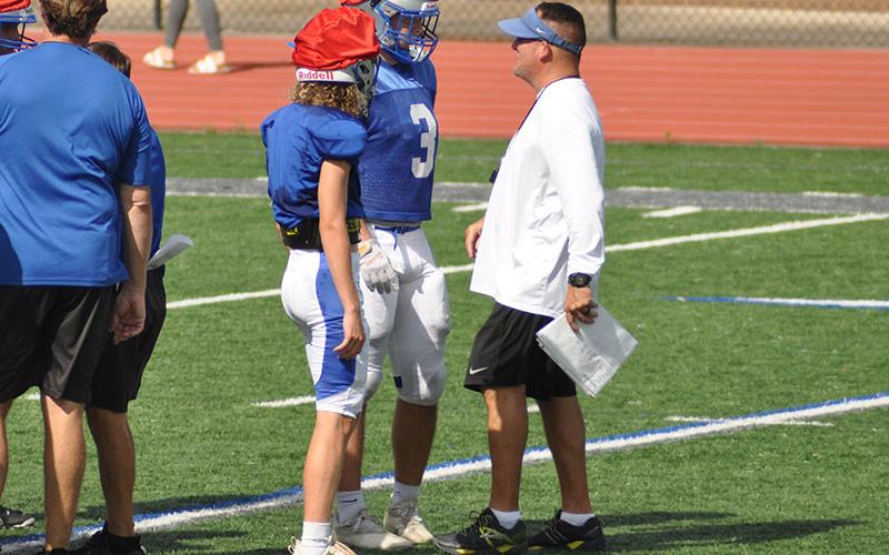The Fannin County Rebels have been working all summer to prepare for the 2022 season. Head Coach Chad Cheatham, right, assists Elijah Weaver, left, and Case Holloway at practice Wednesday, July 27. The Rebels will scrimmage Stephens County at 7:30 at the Fannin County High School Stadium.
