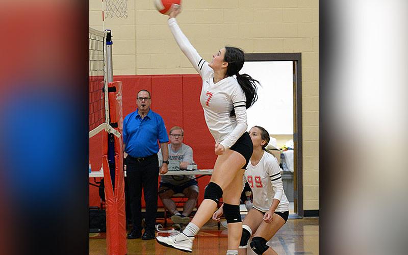Sarah Collis (7) jumps up to hit the ball while Taylee Hall (99) plays in coverage for the Lady Cougars volleyball team Tuesday, September 6, in their match against Lookout Valley.