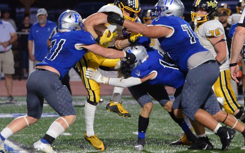 Logan Long (77) leads the defensive charge to stop this Murphy ball carrier Friday night at the Fannin County High School stadium.
