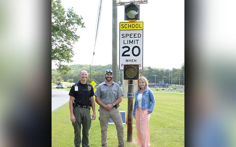 Lieutenant Darvin Couch, Blue Ridge Street Department Supervisor Tony Byrd, and Blue Ridge Mayor Rhonda Haight are shown with the new school zone warning lights in front of Fannin County Middle School. The city paid for the safety improvement.