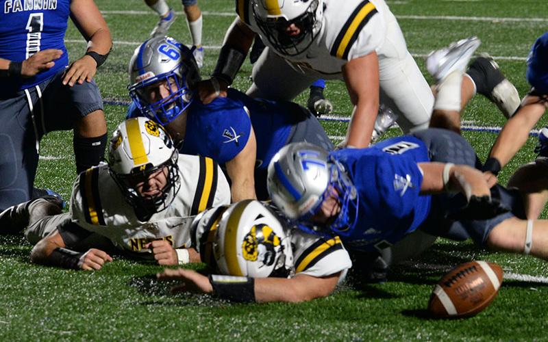 Bryan Stiles (66) and Jeremy Tammen (71) tackle two North Murray Mountaineers to force a fumble and Brayden Taylor (10) eyes the loose ball and quickly recovers it in last week’s record breaking win for the Fannin Rebels.
