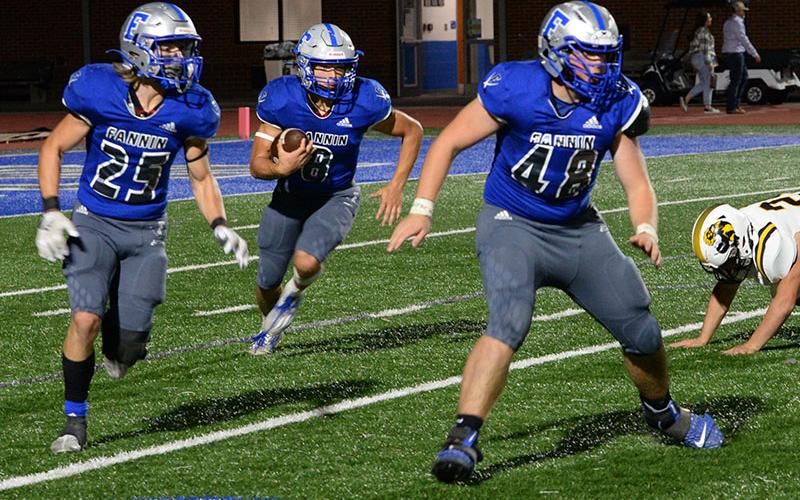 Corbin Davenport (8) runs the ball behind teammates Carson Callihan (25) and Baylor Twiggs (48) as they clear the way in recent action for the Rebels.