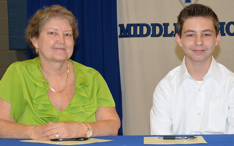 Ronald Kendall is shown with his mother, Karen Kendall, after they signed his REACH contract.