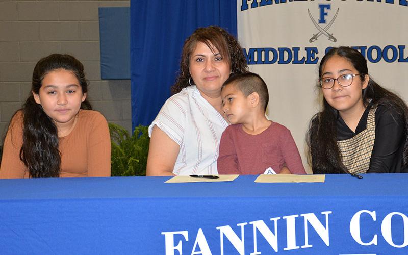 Lesly Alvarado, right, is one of this year’s REACH scholars at Fannin County Middle School. Her mom, Hidolina Alvarado joined her in her contract signing along with Camila Alvarado, left, and Sebastian Alvarado.
