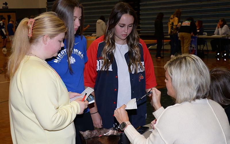 Lyla Webb, Bridgette Allen and Cheyenne Beavers get help from Stacy Lewis of Mountain Valley Community Bank during Reality Day at Fannin County High School last week.