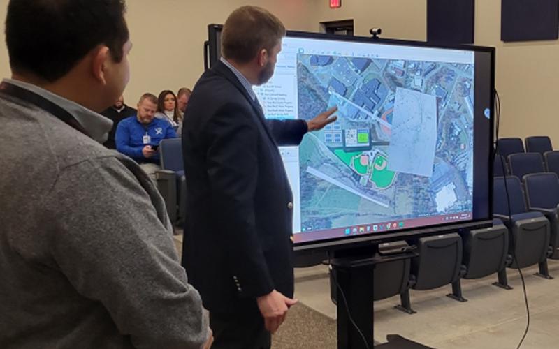 School Superintendent Dr. Michael Gwatney describes some of the plans for the land behind Fannin County High School to school board members Friday morning. At left is the architect for the project, Henry Pineda.