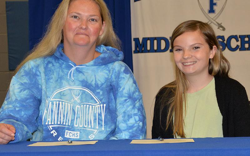 Sarah Brawley, right, is shown after she and her mother, Jessica Whitlow, signed her REACH contract.