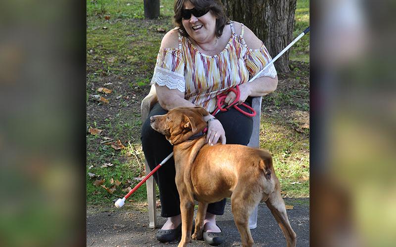 Debi Holcomb, a volunteer at the Fannin County Animal Control, is shown with Archie, who has been at the Animal Control facility for over a year. Holcomb recently adopted Archie despite several setbacks. Many volunteers gathered at her house to build Archie his very own dog house and fenced in yard.