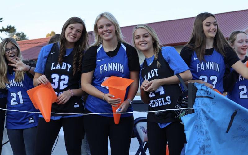 Hallee Walton, Macy Hawkins, Emma Holloway, Riley Reeves, Reese Lewis and Emma Buchanan smile and throw out candy from the Lady Rebels’ Basketball float in the Paint the Town Blue Homecoming Parade through downtown Blue Ridge Tuesday, October 11.