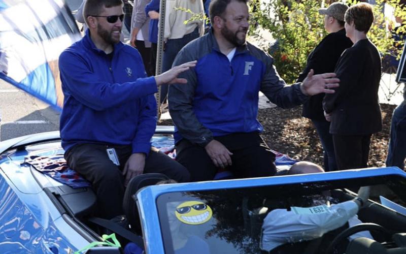 Superintendent Dr. Michael Gwatney and Fannin County High School Princpal Dr. Scott Ramsey wave to bystanders at the Paint the Town Blue Homecoming Parade through downtown Blue Ridge Tuesday, October 11.
