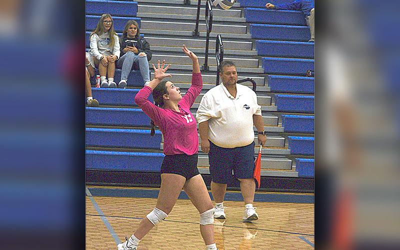 Libero Maddie Pelfrey (13) watches the ball before her serve during the playoff match this past week.