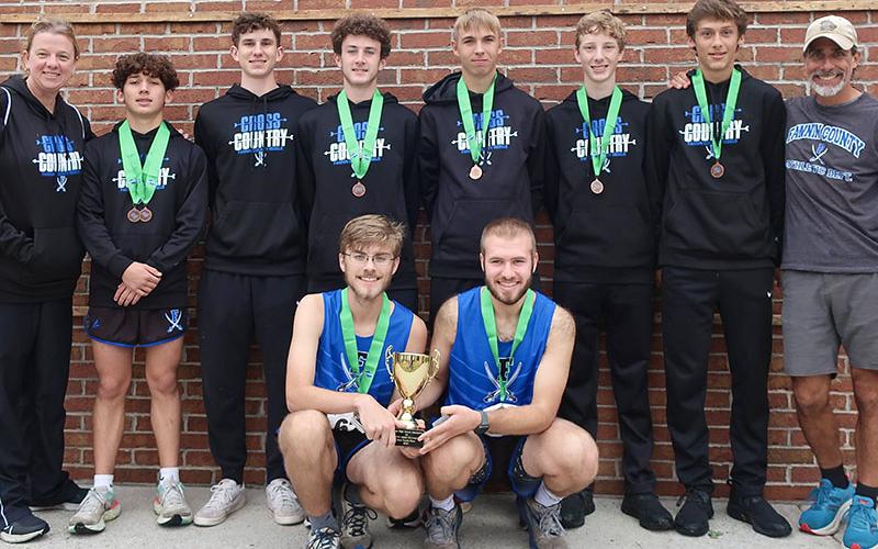 The FCHS Men’s cross country team smiles after a fourth place finish in the State Meet. Shown are, from left Coach Pass, Zechariah Prater, Phoenix Leifer, Conner Kyle, Gaven Davis, Luke Callihan, Benjamin Bloch, Coach Cosentino and kneeling seniors James Kyle and Sam Jabaley.
