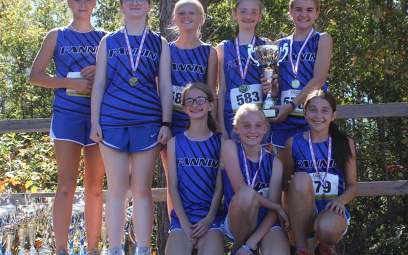 The Fannin County Middle School girls’ cross country team smile and hold their trophy as Georgia Grand Champions. Shown are, from left, back row. Kensley Pickelsimer, Claire Saxon, Karleigh-Jane Stiles, Lola Temples and Annaleigh Cheatham; and front row, Sydney Ford, Jacquelyn Cline and Sadie Patton.