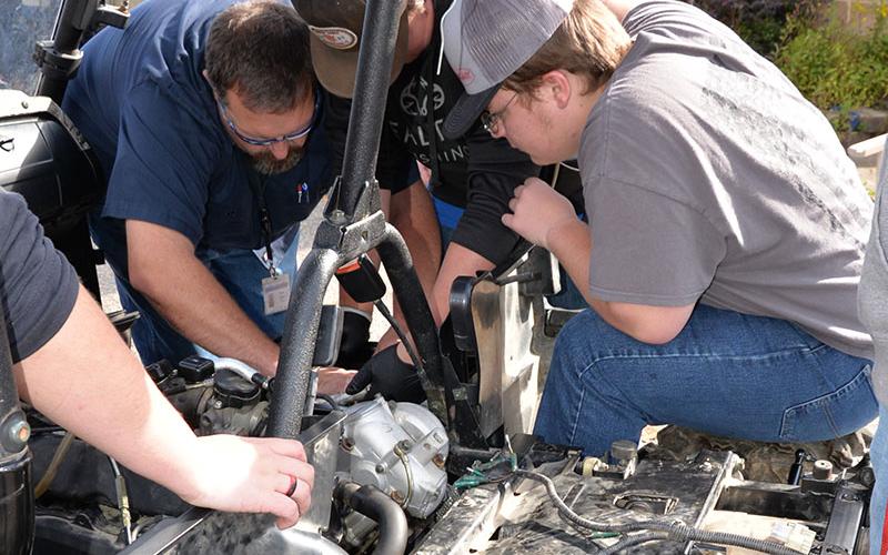 Automotive Technology instructor Daven Dilbeck helps Dakota Rutledge and Drew McDaris who was working with a team of Automotive 1 students to find why a four-wheeler would not start.