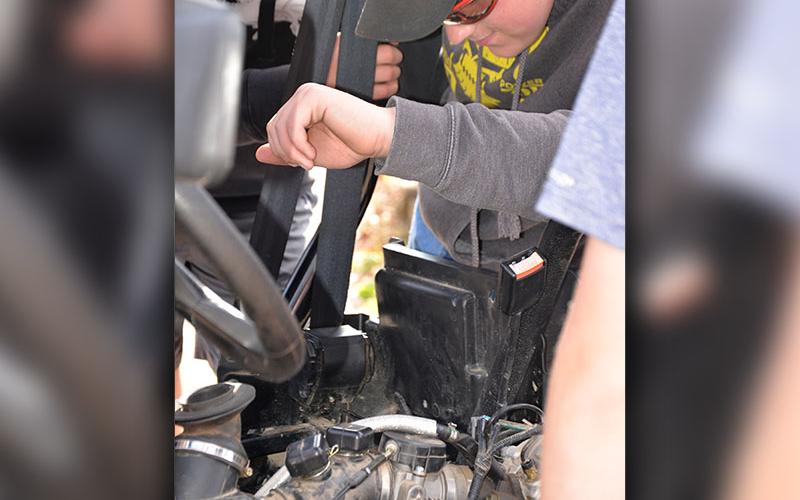 Conner Fisher and Vince Foster look closely at the Automotive Technology challenge.