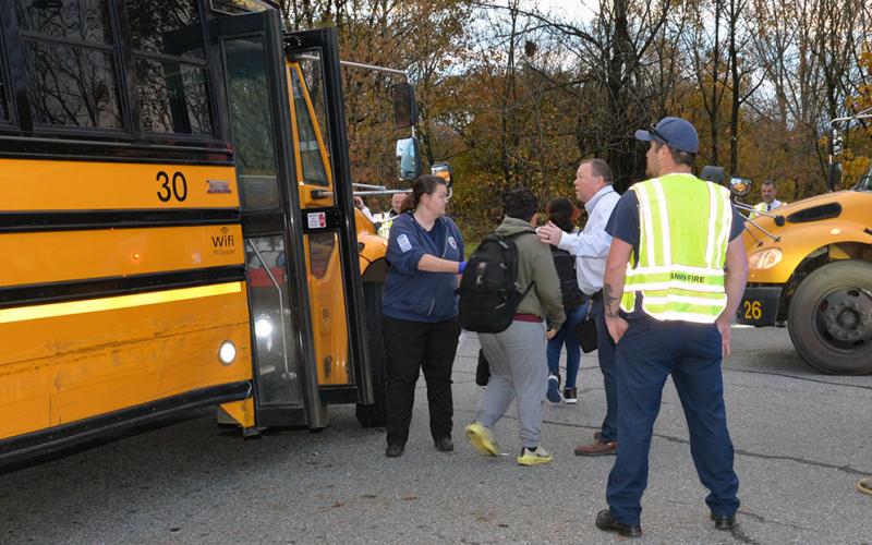 Fannin County Emergency Medical Services Director Becky Huffman and school system Assistant Superintendent Robert Ensley help move children from the Fannin County school bus involved in Tuesday’s crash to another bus.