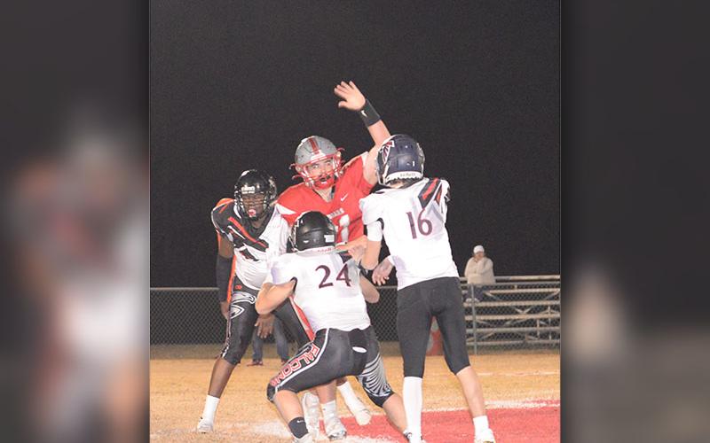 Addison Hook (61) jumps and throws a hand up to try to deflect the pass made by the opposing quarterback.