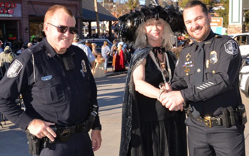 McCaysville Police Chief Michael Earley, right, and Officer Pete Kusek  were not sure about the  intention of this  visitor at McCaysville’s Safe Zone, so they detained her for questions. She turned out to be city Councilman Susan Kiker who proclaimed to ba a “good witch” watching over the festivities.