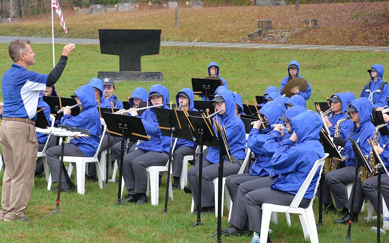 The Fannin County High School band, under the direction of Scott Barnstead, left, braved the Saturday rain to perform patriotic music during ceremonies in the Fannin County Veterans Memorial Park.