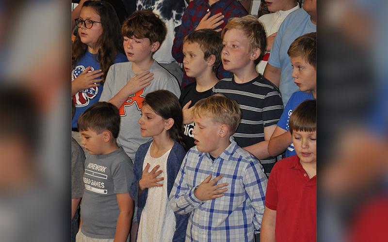 Students are shown singing the National Anthem during East Fannin Elementary School’s (EFES) Veteran’s Day Program November 9. Front row, from left, are EFES students Landon Graham, Karrissa Martin, Ty McClure and Ryan McGillis. Next row, from left, are Emmalynn Dye, Cooper Highley, Cullen Kimsey, Ricky Davis and Yates Eavenson.