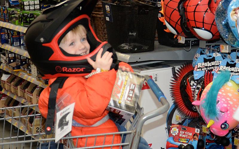 This young man just had to try on this helmet to go along with his new bicycle. He finally gave up and agreed to a smaller size.