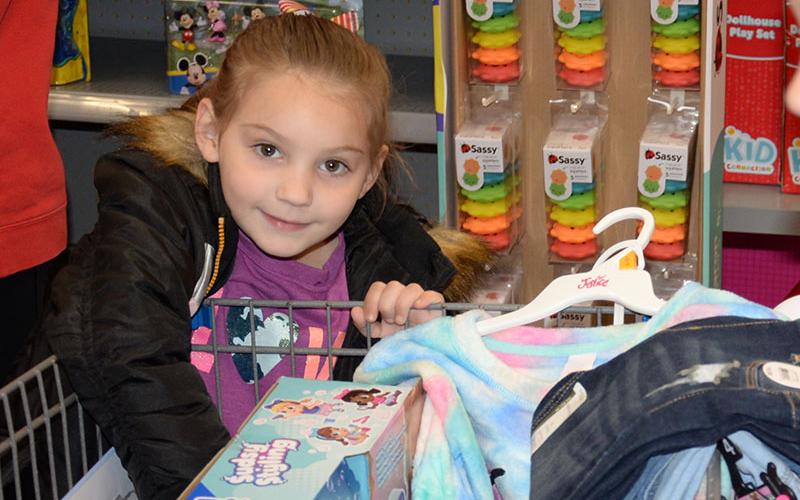 Look what I have! This young shopper was excited to show off the toys and clothes she received during Shop With a Cop.
