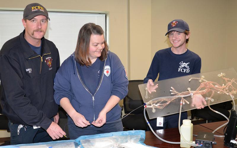 Advanced EMT Daniel Elrod, Paramedic Becky Huffman and intern Trent Lowery, from left, made up the Fannin County EMS ambulance crew that responded to the home of an 88-year-old stroke victim. Here, they try out the advanced technology used at Kennestone that was used to treat the patient.