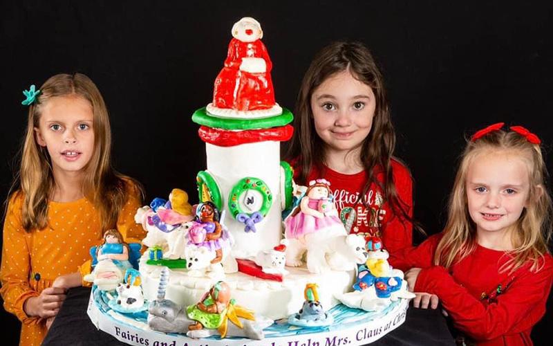 The “Glitter Girls” took third place in the Child Division of the National Gingerbread Competition in Asheville, North Carolina. Their creation showcased Mrs. Claus and her Arctic friends. Shown, from left, are Sarah Miller, Violet Lake, and Bryna Thompson.