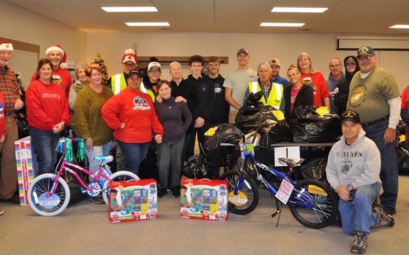 The Toys for Tots Christmas toy drive commenced Friday, December 16, at Family Connections when this group of volunteers were among those passing out the thousands of toys collected. Shown are, from left, front row, are Jody Guttridge, Dale Greene, Claire Bryant, Jan Carney, Cheryl Jordan, Olivia Coffone, Joel Warner, Brandie Forrestier and Greg Coffone. Second row, from left, are Ian Guttridge, Sue Warner, Dick Evelyn, Sheila Lenord, Thelma Coffone, Conner Kyle, James Kyle, Bryce Ware, Sam Jabaley, Gale Ma
