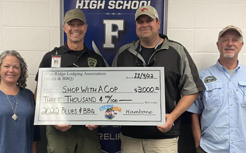 Fannin County Deputy Sheriff and School Resource Officer Commander Lieutenant Darvin Couch, second from left, accepted a check for $3,000 toward Fannin County Shop With A Cop from Blues &amp; BBQ coordinators, from left, Dena Martin, Paul Gribble and Greg Spencer.