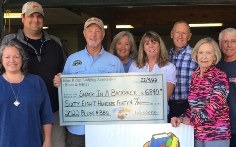 The 2022 Blues &amp; BBQ festival raised more than $20,000 to be given to local charities that work to take care of area children. Here, Blues &amp; BBQ organizers, from left, Dena Martin, Paul Gribble and Greg Spencer present a check for $6,840 to Snack in a Backpack Director Deby Beck and several of the volunteer who work with the organization. Snack in a Backpack provides food for Fannin County during the school year to take home on weekends and during tyhe summer thorough a cooperative effort with several local