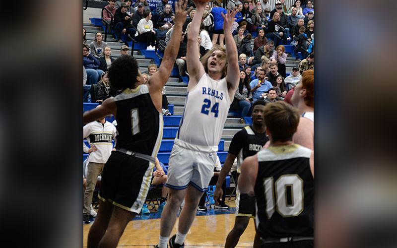 The Rebels’ Bryson Wright shoots a contested jump shot in basketball action.