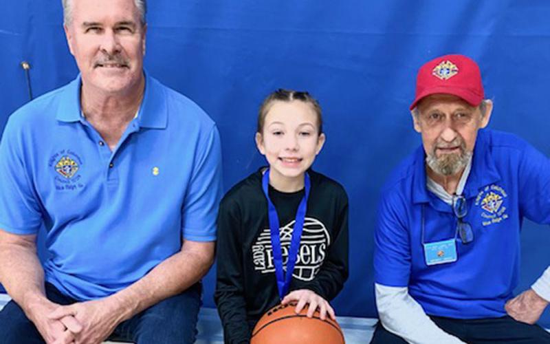 Jack Devine and Gerald Renny are shown with Molly Prince, the 11-year-old girls free throw winner.