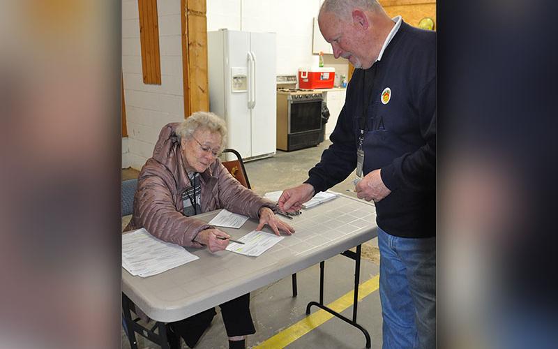 Polls were open at the Colwell voting precinct January 31, where 95 year old Anne Bailey is pictured assisting a voter.