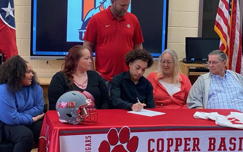 A.J. Fitchett is shown as he signs his letter of intent last week to play football for Union College in Barbourville, Kentucky. Shown during the ceremony are, from left, seated, Jadyn Fitchett, Jaclyn Miles, Fitchett, Susan Miles and Allen Miles; and standing, Copper Basin Head Football Coach Chad Grabowski.