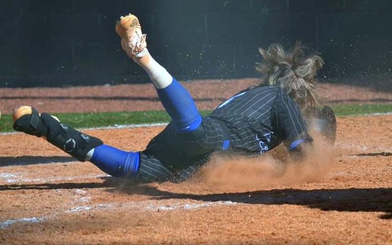 Carson Callihan slides into home plate for an “in-the-park” home run Saturday, March 18.