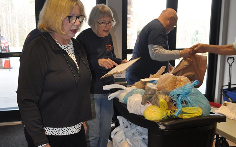 Sandy Cuppia, Sylvia Goodyear and Greg Duncan make sure bags are ready for delivery as part of the food ministry at Faith Presbyterian Church.