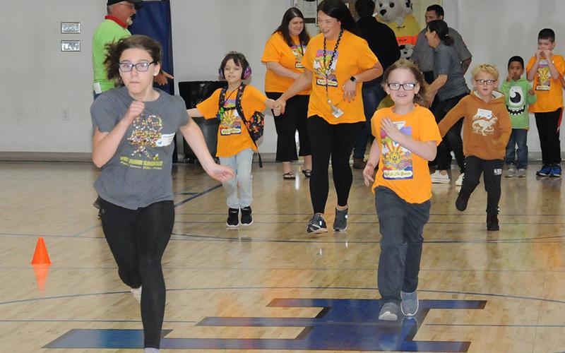 The race is on between West Fannin Elemntary’s Christina Evans, Artemus Fowler, Ezra Lee and Kaiden Tucker as West Fannin parapro Stephanie Fink lends a helping hand during Special Olympics Track and Field events last week.