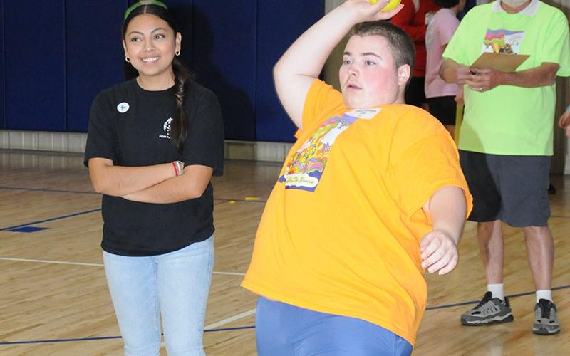 Ethan Firestone from Fannin County High School attempts the winning throw during the Special Olympics Track and Field event as Isabel from the FCHS Partners Club looks on.