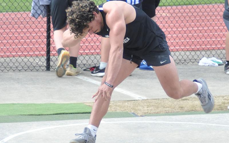 Senior Andrew Waldrep positions himself to throw during the shot put field event Tuesday, March 28, at Coahulla Creek.