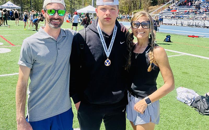 Senior Matthew Crowder, center, placed third in shot put at the Marietta High School Spring Break Invitational. Crowder is pictured with Coach Lucas Roof, left, and Head Coach Miranda Roof, right.
