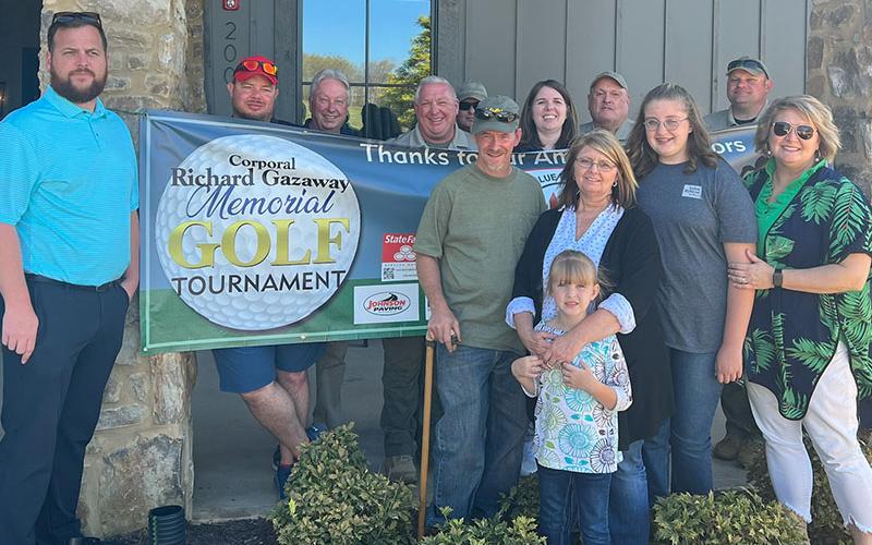 Richard and Heather Gazaway’s daughters, Skylar and Riley, and several other family members were among special guests at the Coporal Richard Gazaway Memorial Golf Tourney. They are shown in front of the banner with Wayne and Glenda Stover and Dawn Jamison. Among the many volunteers who worked to organize the tournament and make it a success are, from left, Dustin Carder, Jacob Pless, Todd Pack, Charles Yannis, Justin Turner, Amber Twiggs, J.K, Davenport, and Brad Mathis.