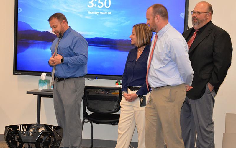 Dr. Scott Ramsey, left, Fannin County High School principal, describes the burn pit made by Fannin County High School students as a special gift to Dr. Michael Gwatney from the principals at the system’s five schools. Also shown during the presentation are, from left, Alison Danner from West Fannin, Matt Price from East Fannin, and Mark Young from Fannin County Middle School.