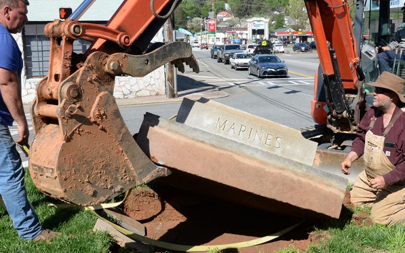 Albert Queen, Davy Ensley and Lee Dillard, from left, work to free the base of the Veterans Monument from where it has been a McCaysville landmark since 1946.