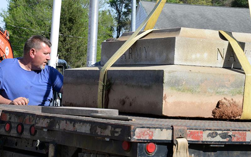 Albert Queen secures the base of the Veterans Monument onto the flatbed truck that carried it from the intersection of Blue Ridge Drive and West Tennessee Avenue to the expanded Toccoa River Park.