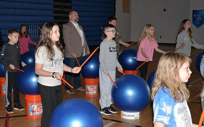 School board member Mike Cole learns some musical skills from East Fannin students, from back to front, Abigail Hoopaugh, Liam Cole, Luke Shelton, Bristol Falls, Zander Sparks, Lily Cook, Emilie Hamilton and Makenley Hill.