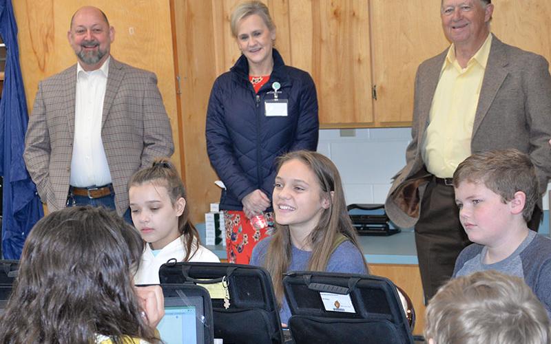 East Fannin Elementary School students Hadley Ciorrocco, Selah Patterson and Sam Hinton, seated, from left, explained the stock market to Mike Cole, Dr. Connie Huff and Bobby Bearden.