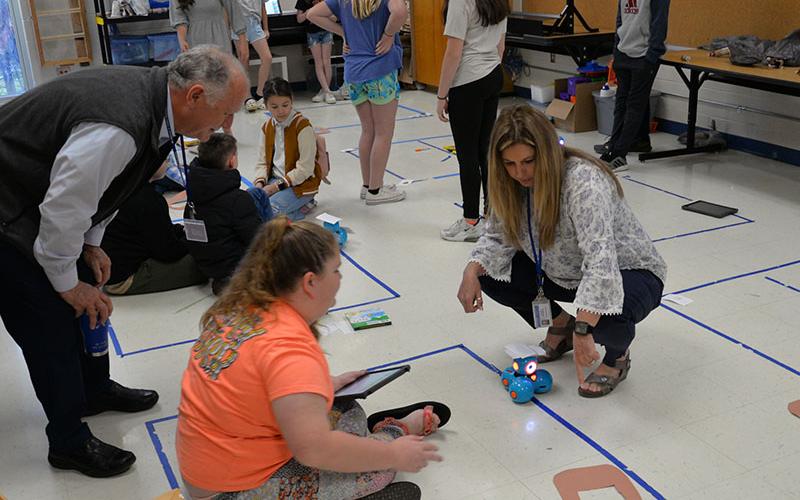 Board of Education Chairman Terry Bramlett, from left, gets a lesson in robotics at East Fannin Elementary from Katie-Ann Tipton and Robin Stephens. The demonstration was part of the school board’s Spring Local Board Training.