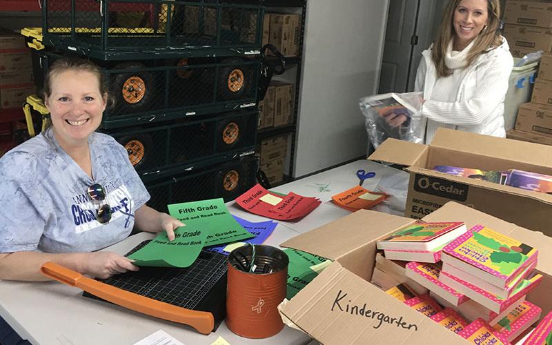 Shown are, left, Gina Farrell and Bethany Higgins, Snack in a Backpack volunteers, helping to organize and pack the books.