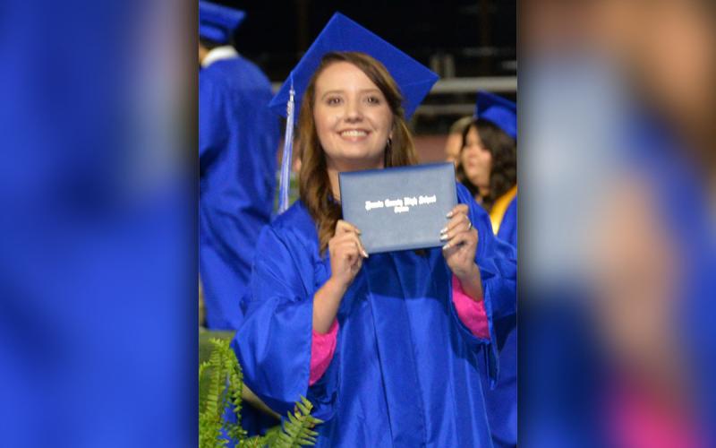Brianna Hulsey shows off her diploma to her family in the stands at Fannin County High School.
